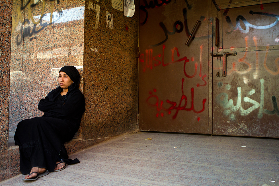 سيدة تجلس في مدخل المشرحة، تجربة مر بها الكثير من المصريين بعد كل حدث مأساوي. أكتوبر/تشرين ثاني ٢٠١٣