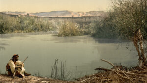 رجل جالس على نهر الأردن.
